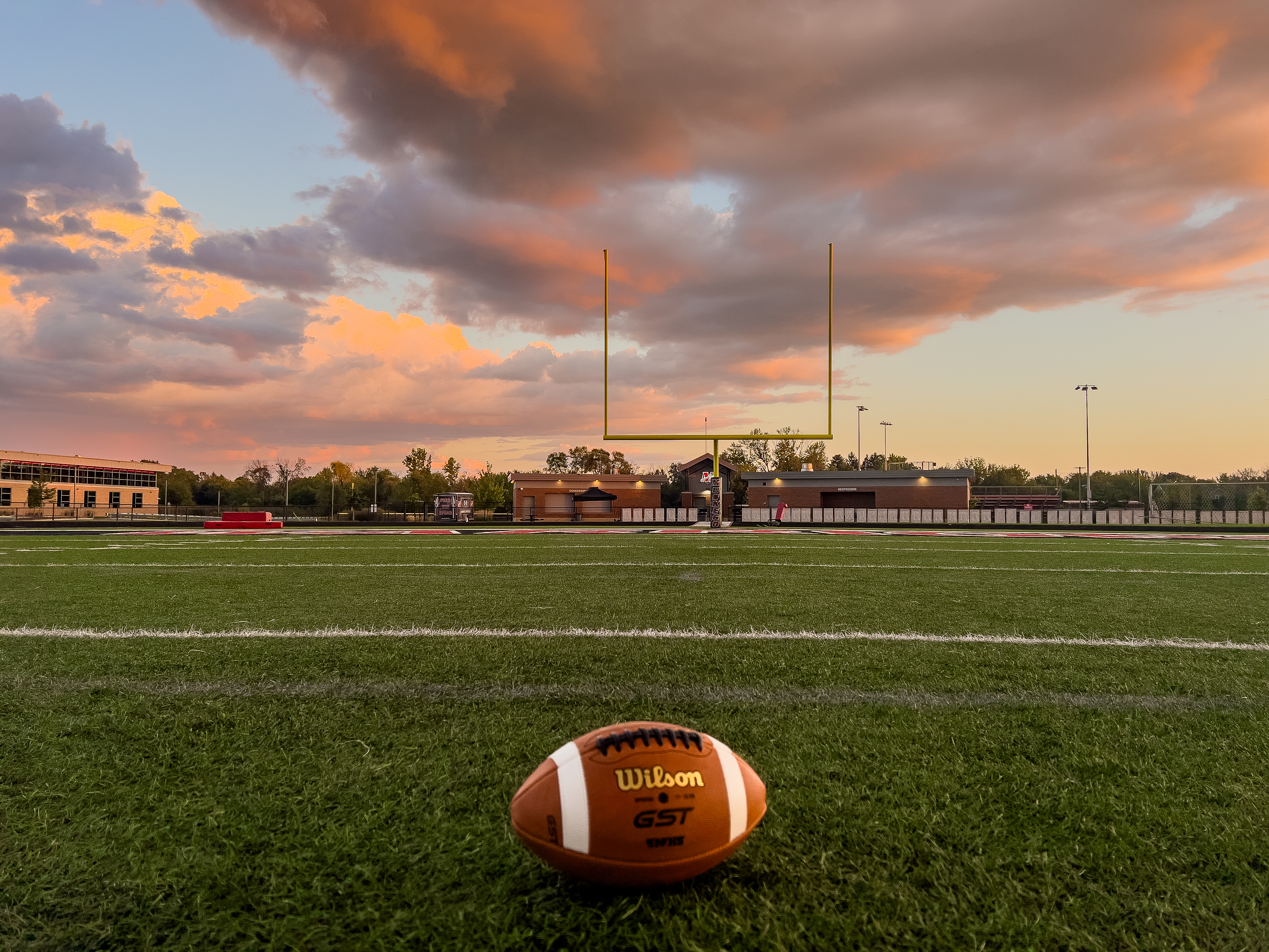 His son holding up the football on the field
